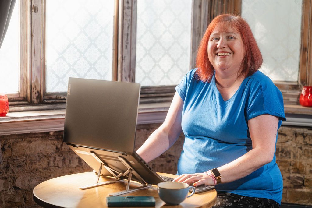A person is typing on a laptop computer at a desk.