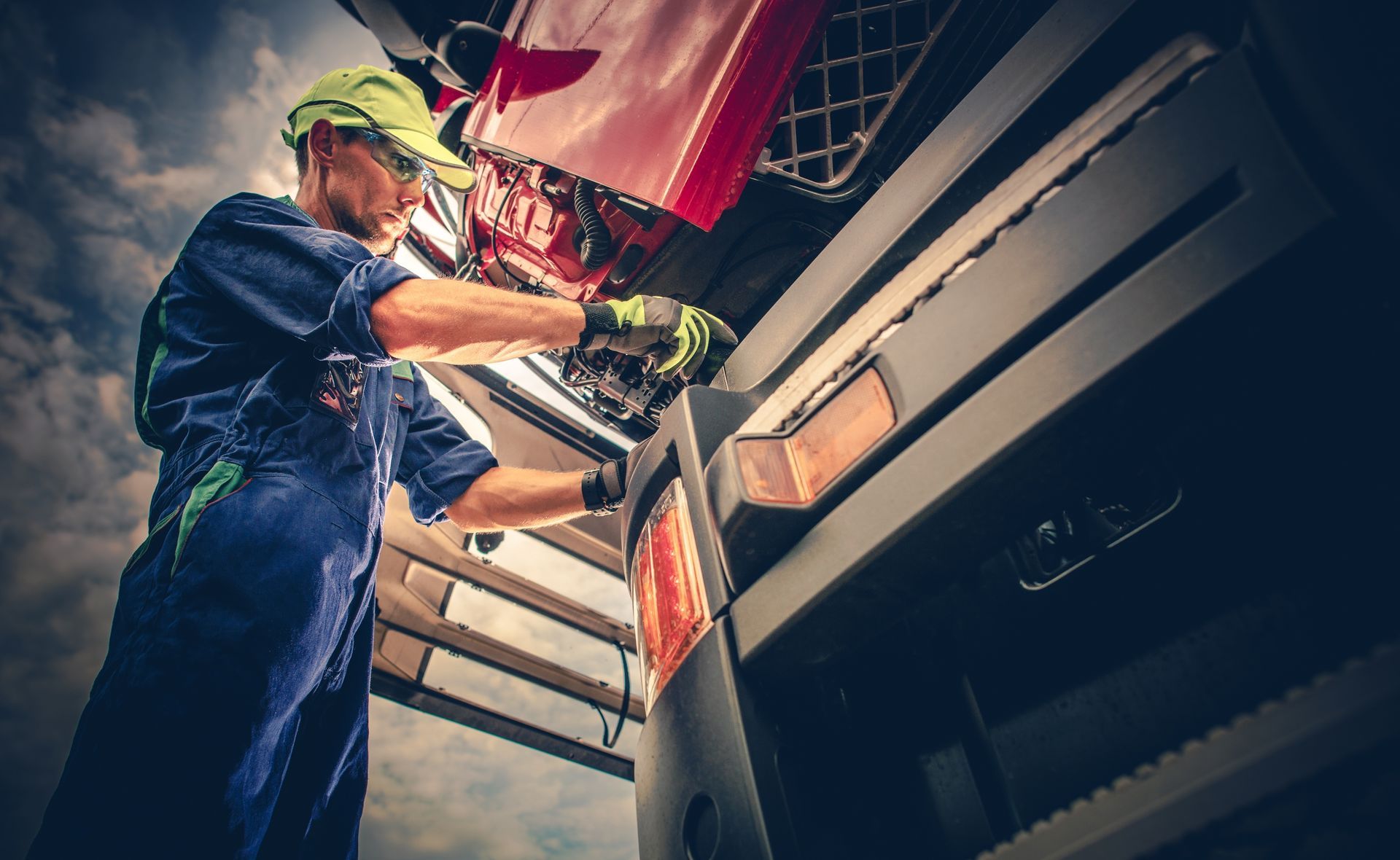 A man is working on the engine of a truck.