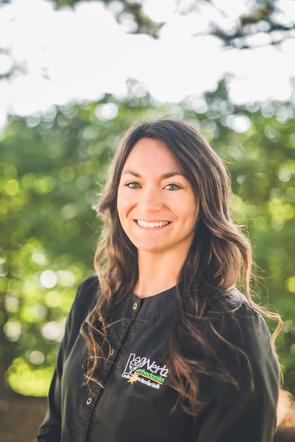 a woman in a black jacket is smiling for the camera .