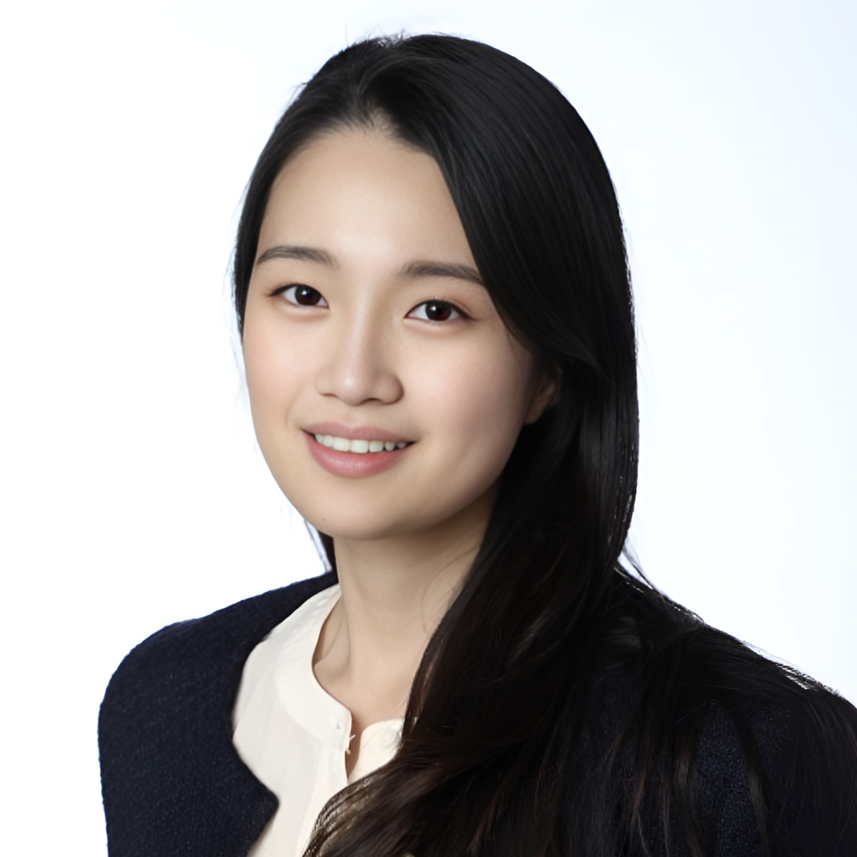 Studio headshot of a smiling woman with long black hair on a white background