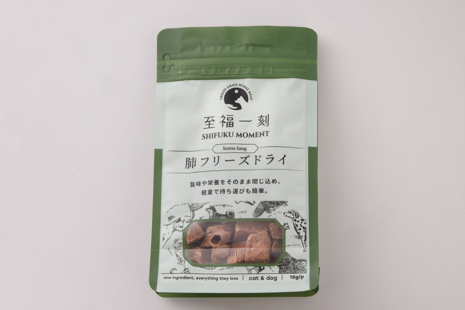 一包冷凍乾燥食品，配有一個碗和一小碟盛放食品的盤子，盤子底面為紅色條紋。旁邊還有蕨類植物和一塊木板。