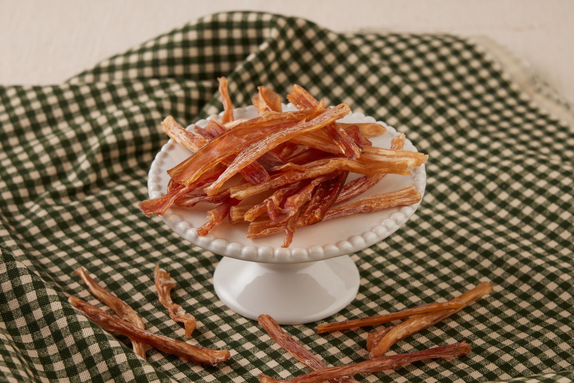 盛放在白色底座碟子裡的乾果條，碟子放在綠白相間的格子佈上。