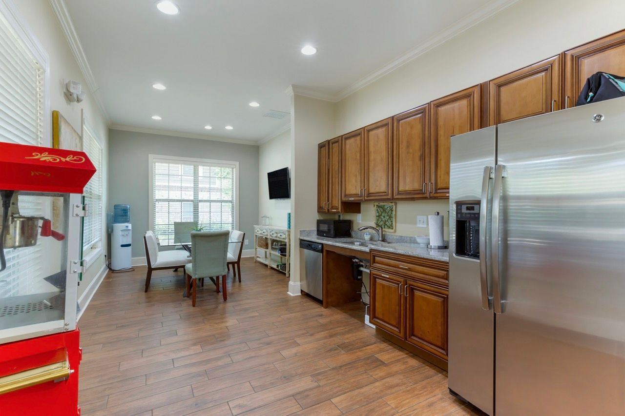 Kitchen with dark wood cabinets, stainless refrigerator, and adjacent dining area.