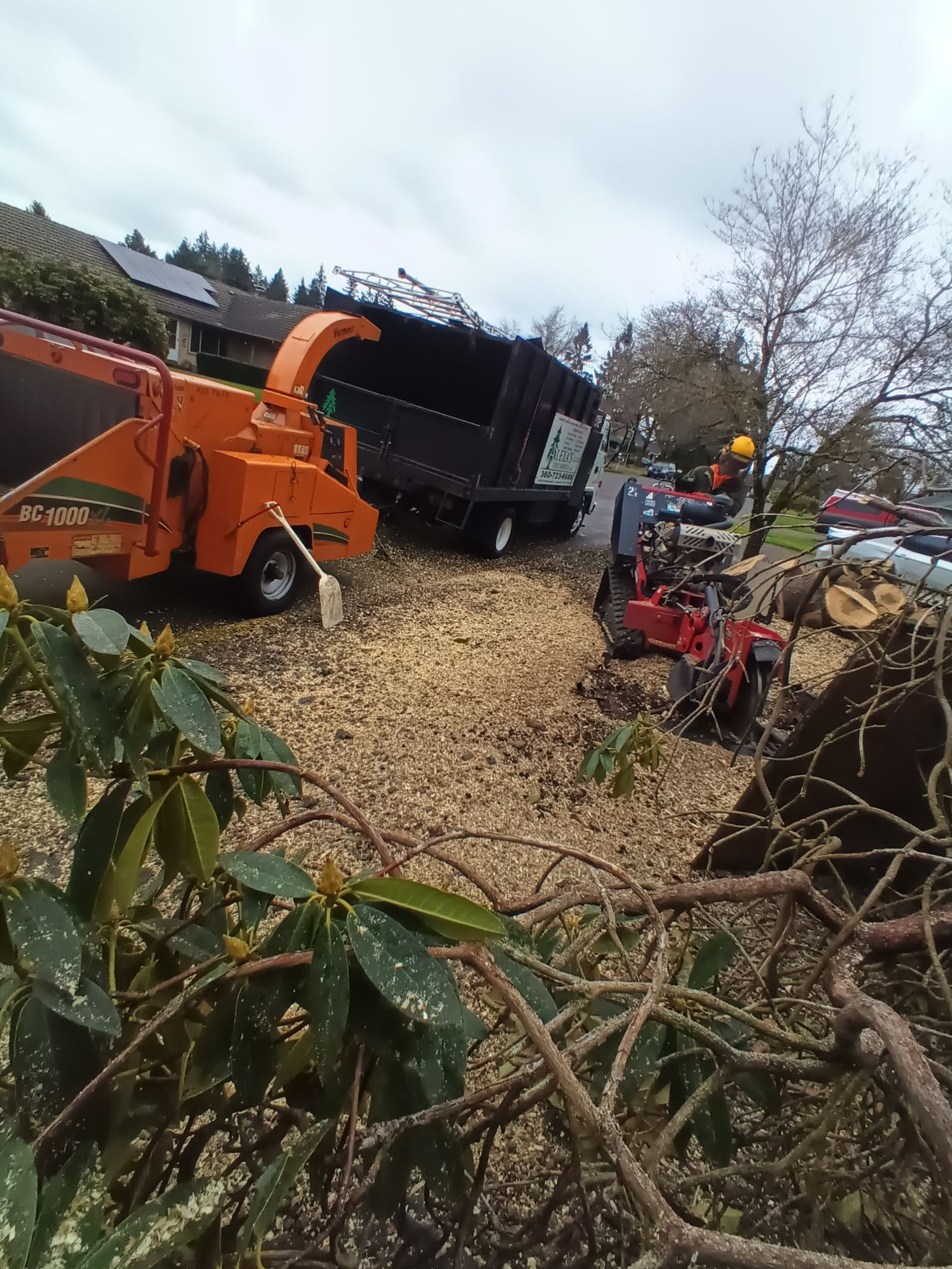 A tree chipper is sitting on top of a pile of wood chips.