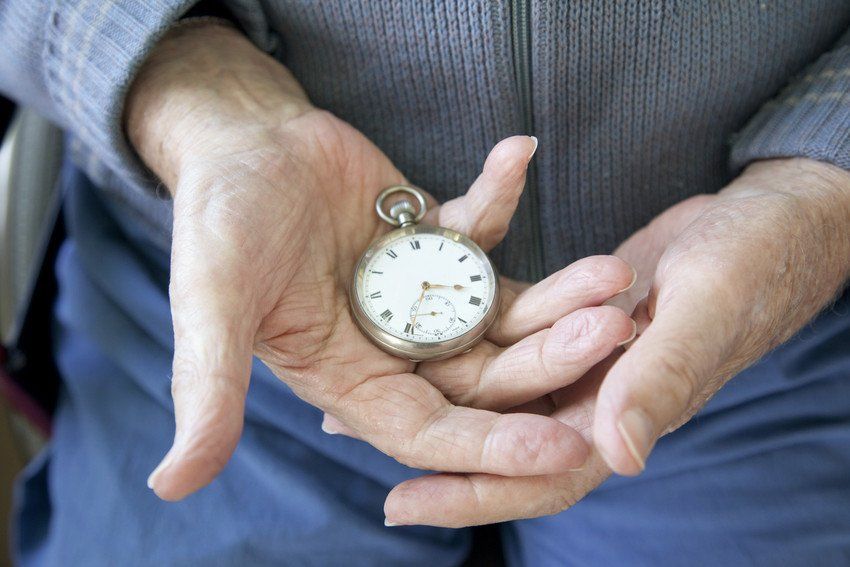 A man holding a antique clock