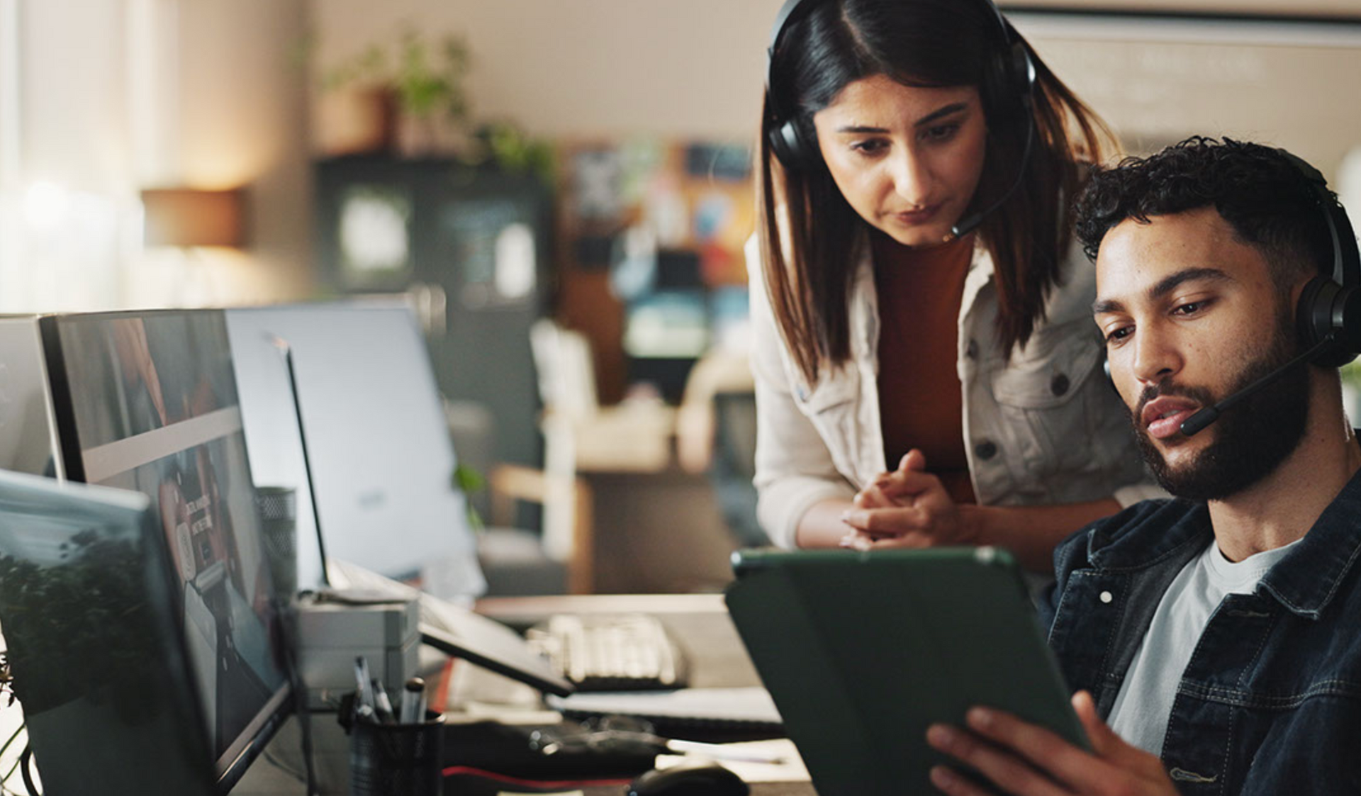 Two men in suits are talking in front of a window