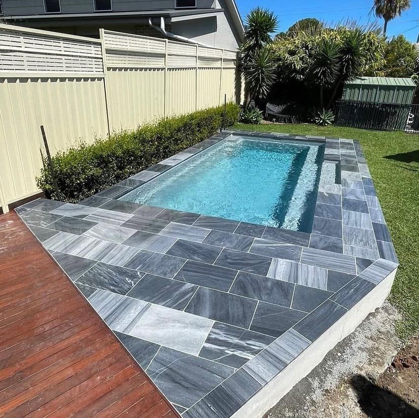 A Swimming Pool Is Surrounded By A Fence And A Wooden Deck — Amber North Coast In Port Macquarie, NSW