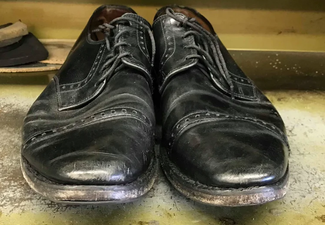 A pair of black shoes are sitting on a table.