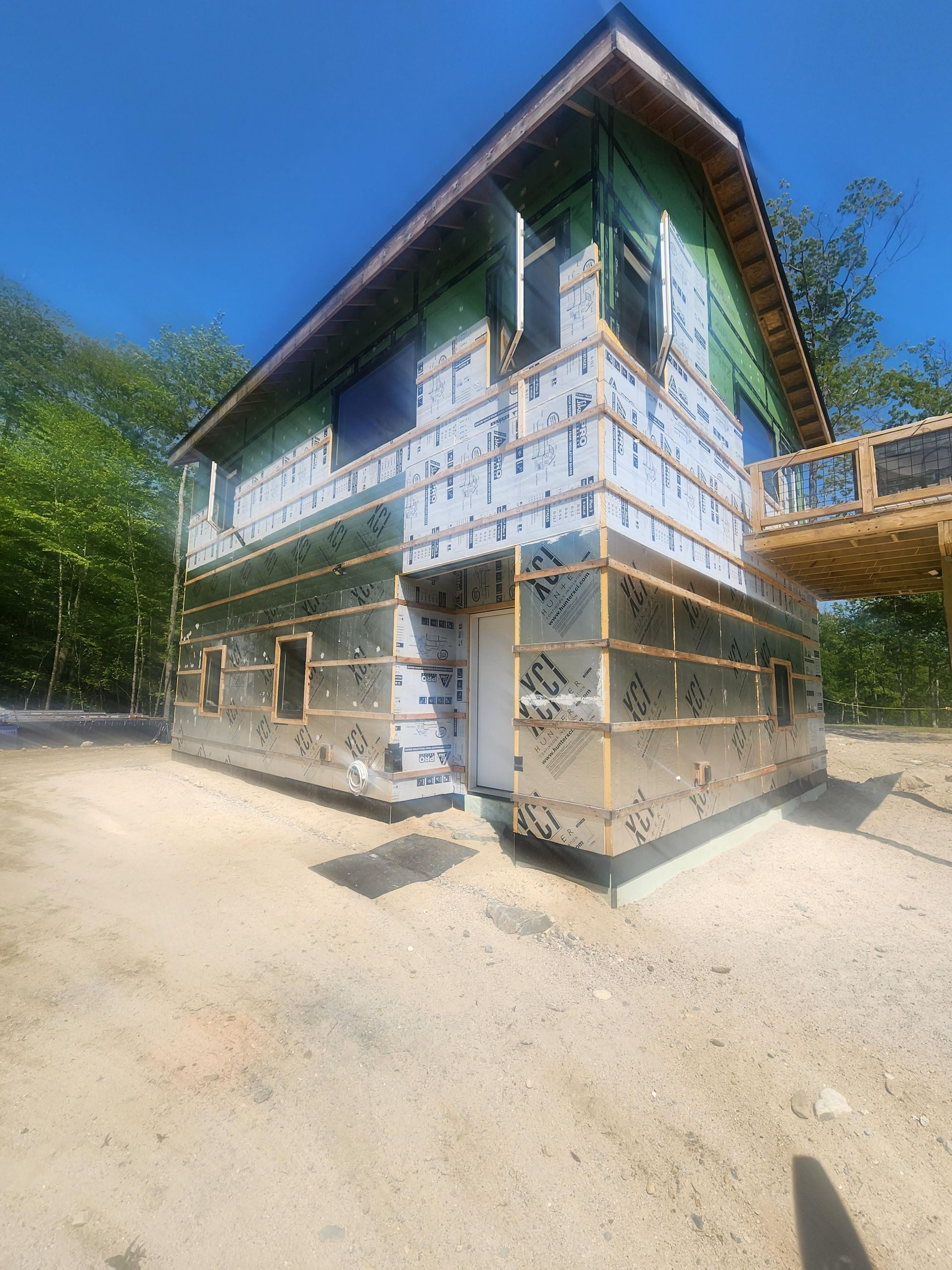 A house is being built in the middle of a dirt field.