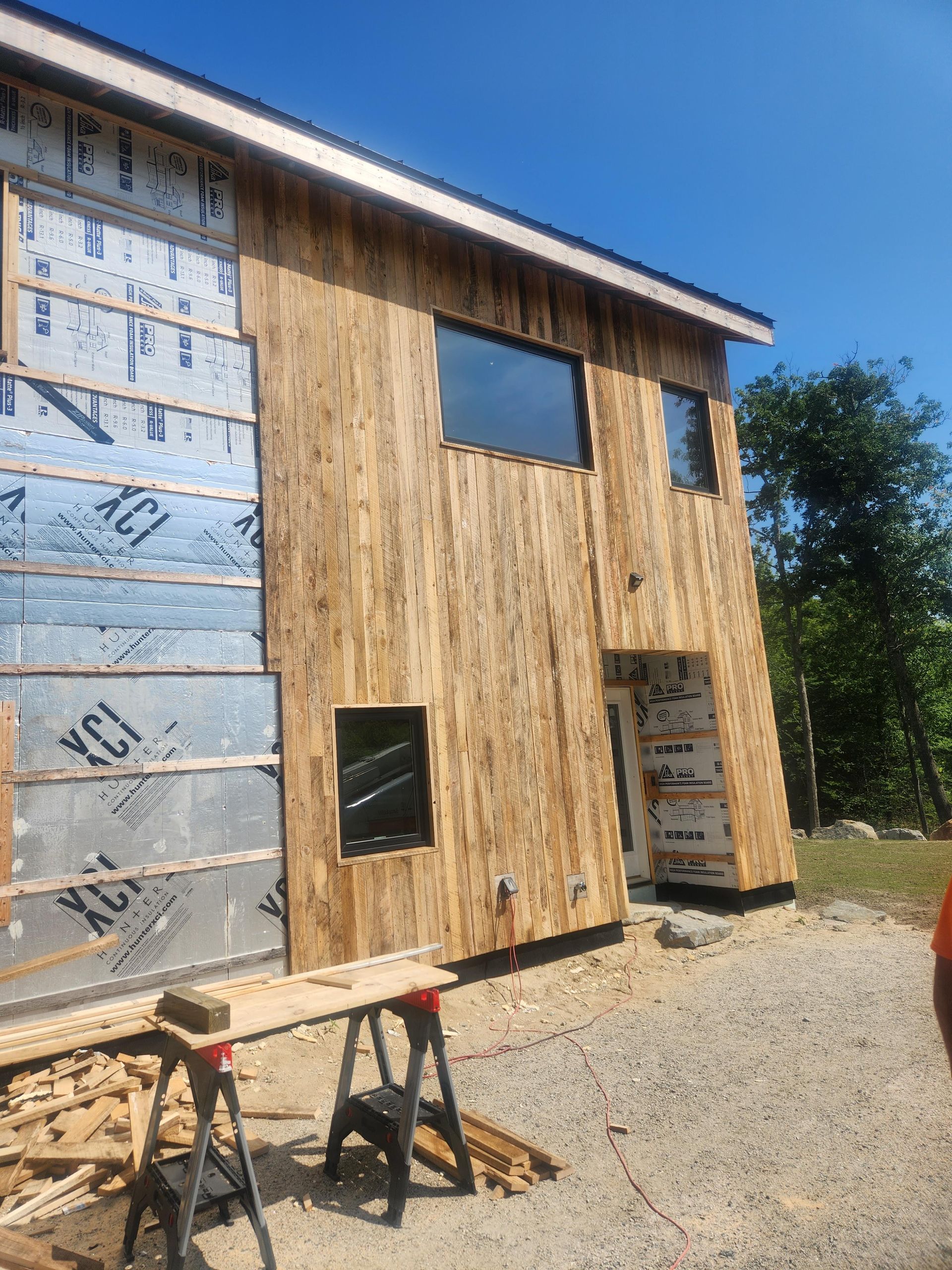 A wooden house is being built with a lot of windows.