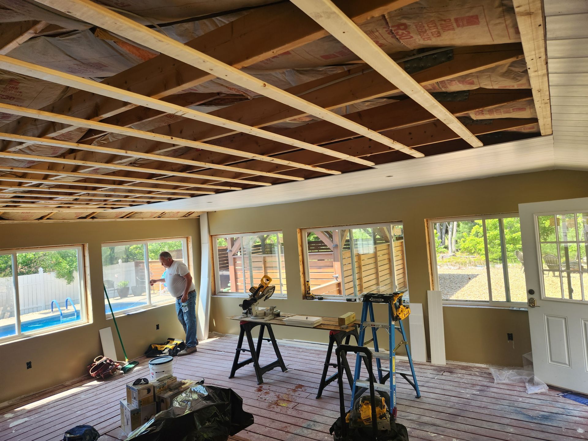 A man is standing in the middle of a room under construction.