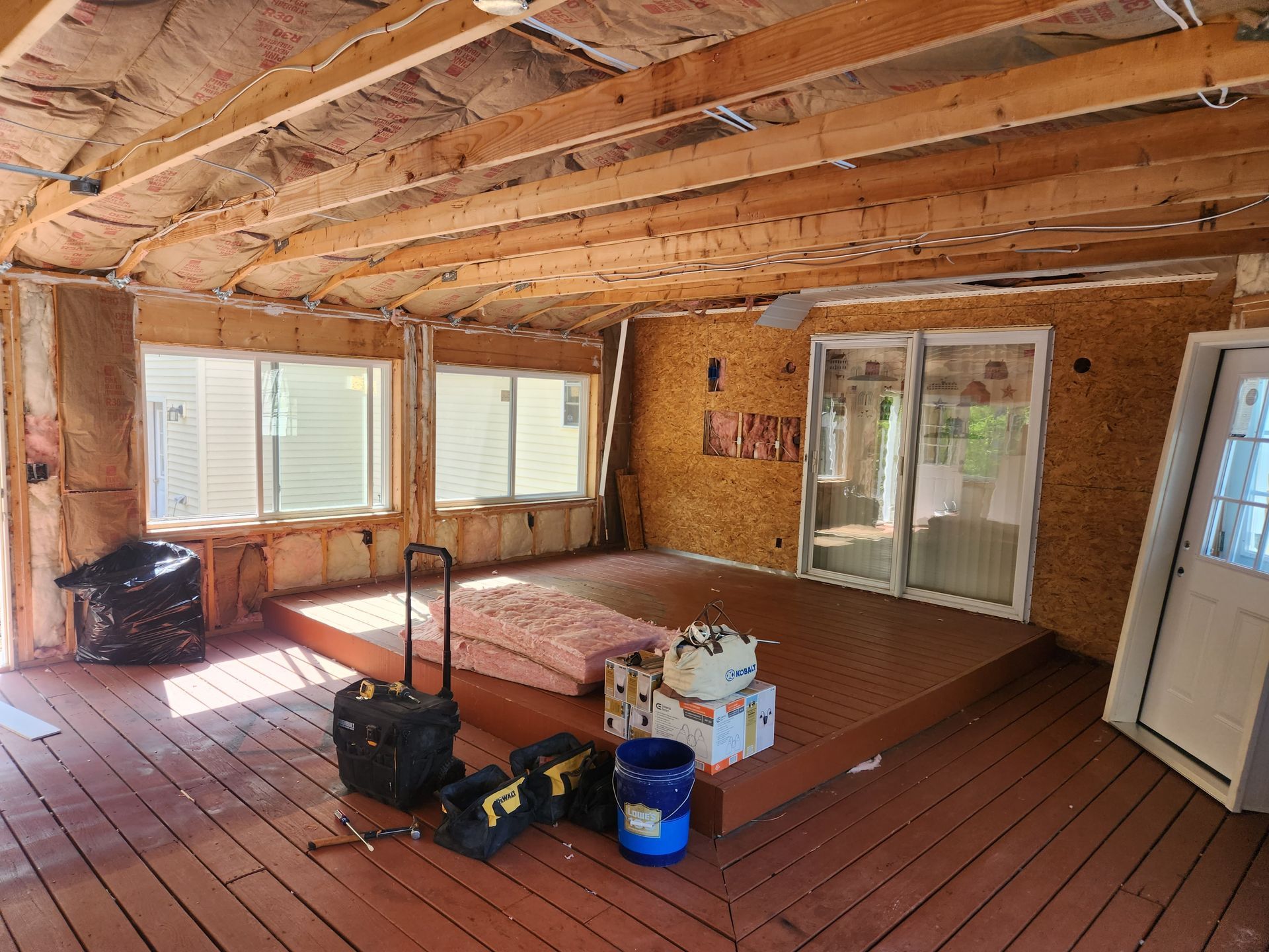 A room with a lot of windows and a wooden floor.