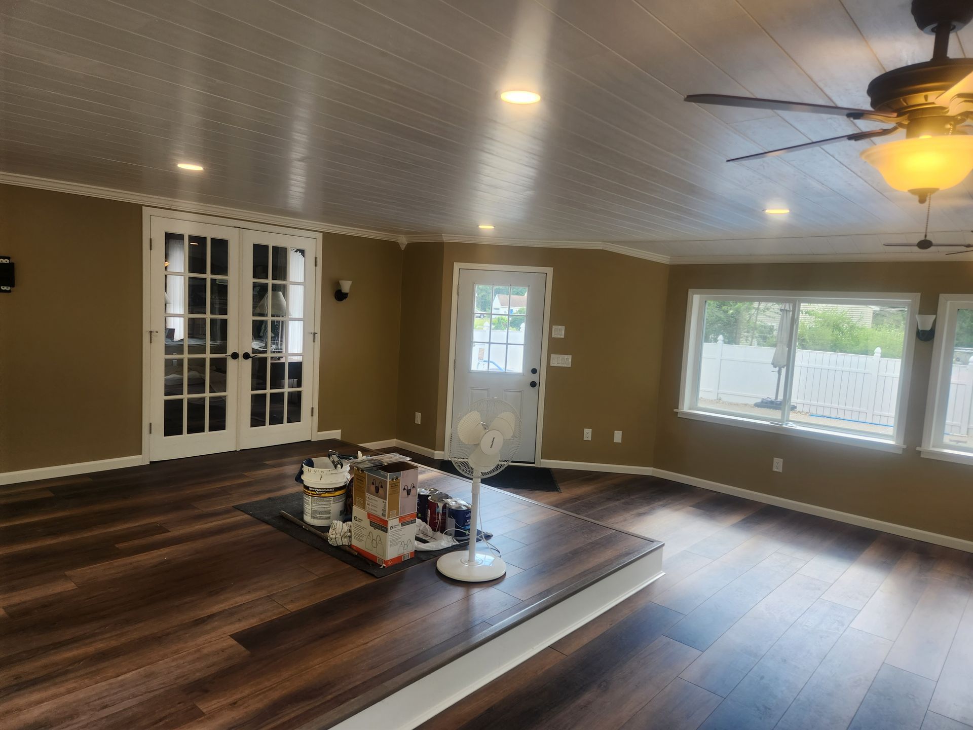 A living room with hardwood floors and a ceiling fan.