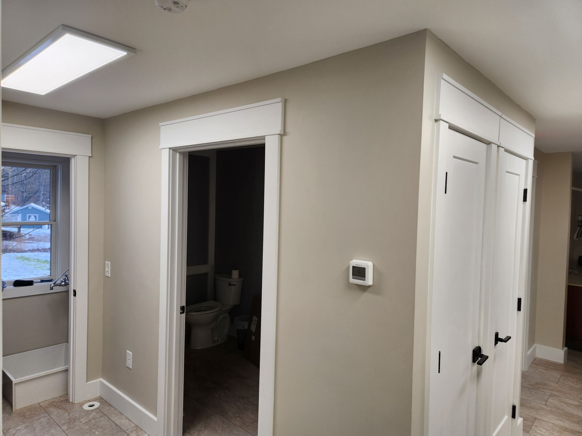 A hallway with a toilet and a bathroom in it