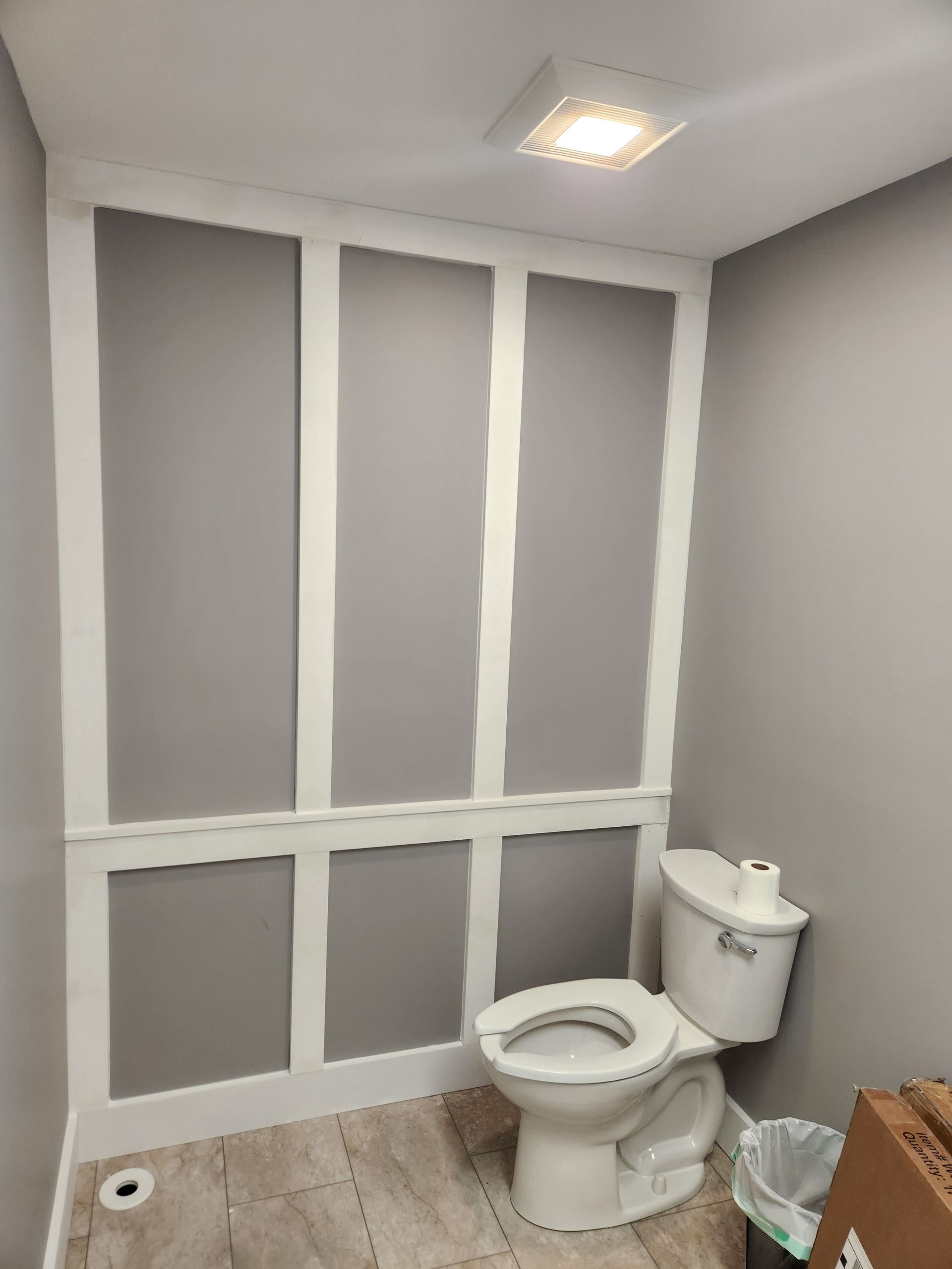 A bathroom with a toilet and a trash can.