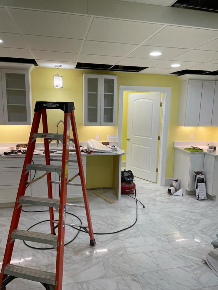 A ladder is sitting in the middle of a kitchen.