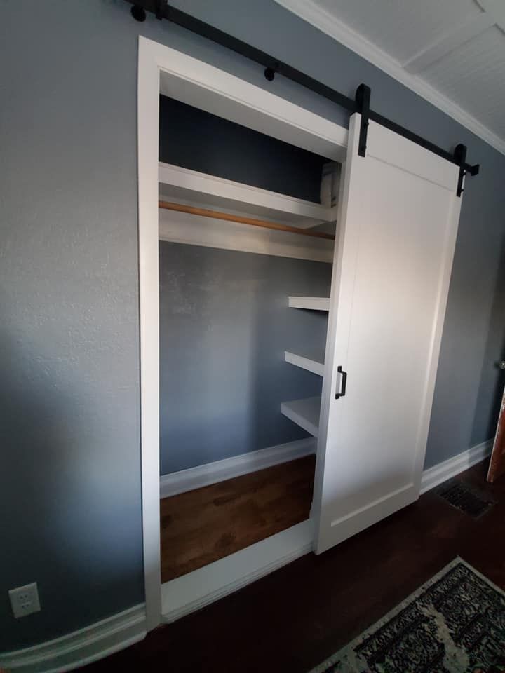 A closet with shelves and a sliding barn door