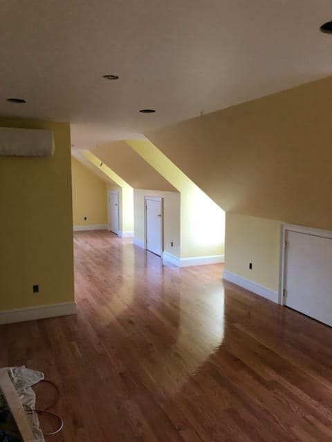 An empty room with hardwood floors and yellow walls