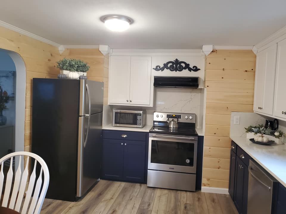 A kitchen with stainless steel appliances and blue cabinets.
