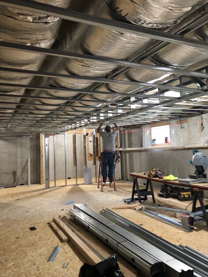 A man is measuring the ceiling of a building.
