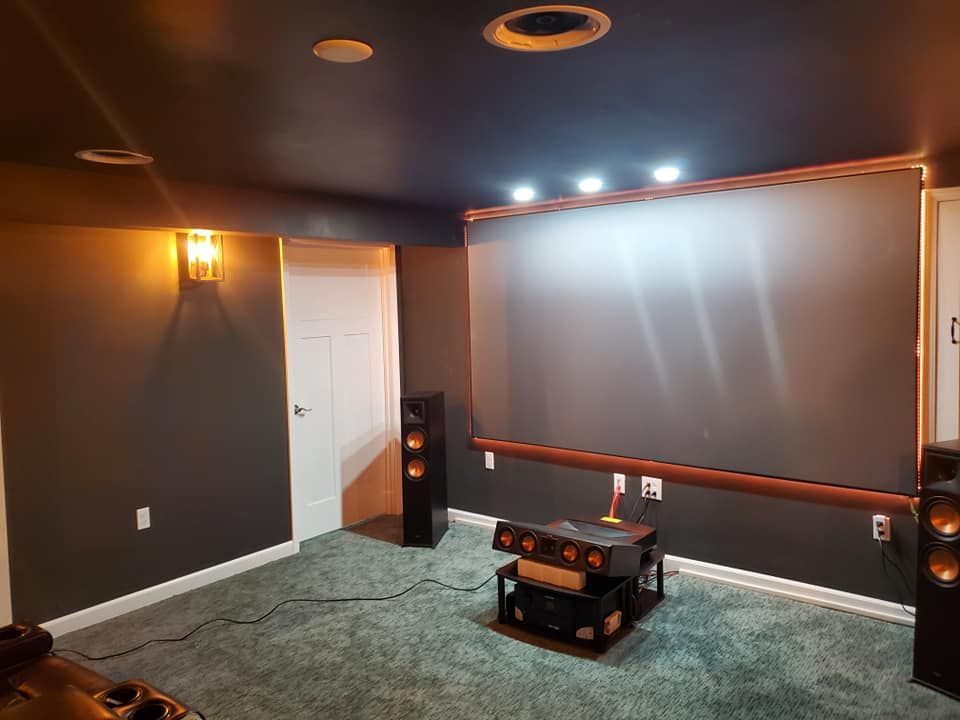 A home theater with a projector screen and speakers.