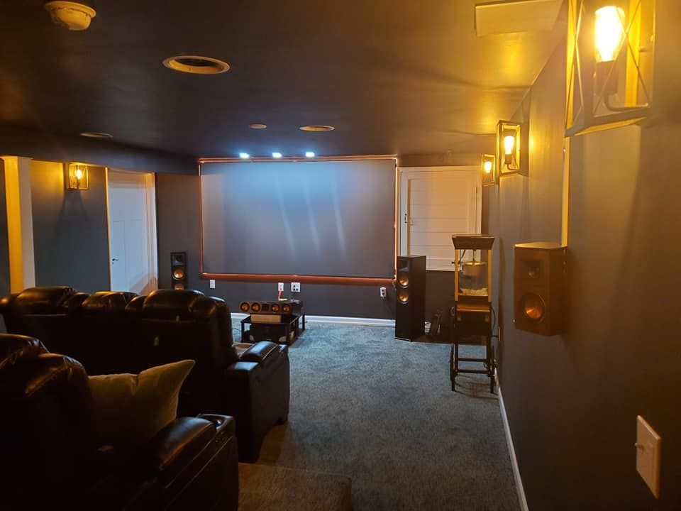 A home theater with a large screen and a lot of furniture.
