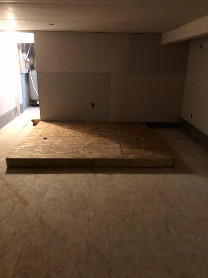 An empty room with a wooden platform in the middle of it.