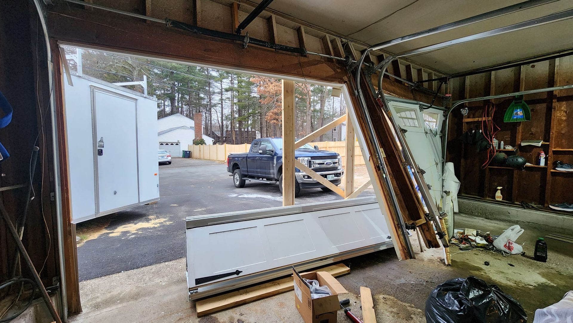 A garage door is open and a truck is parked in the background.