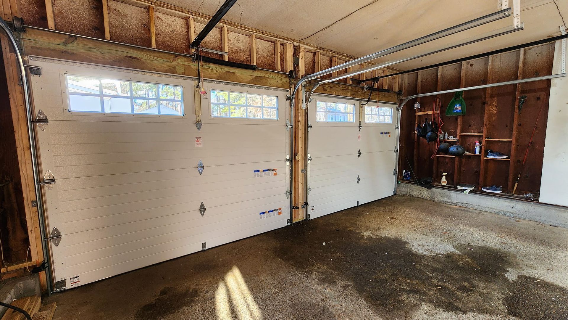 An empty garage with a garage door open.
