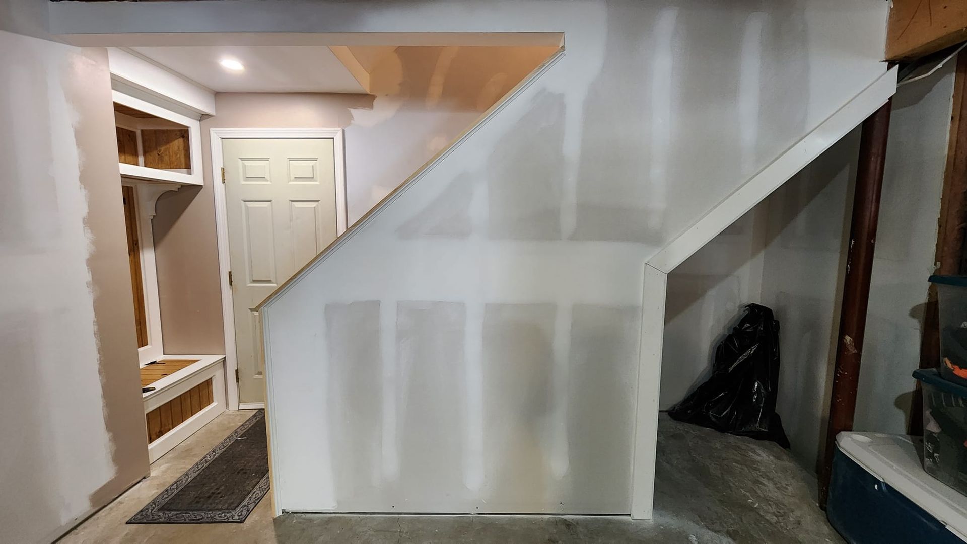 A room with a staircase and a door in it.