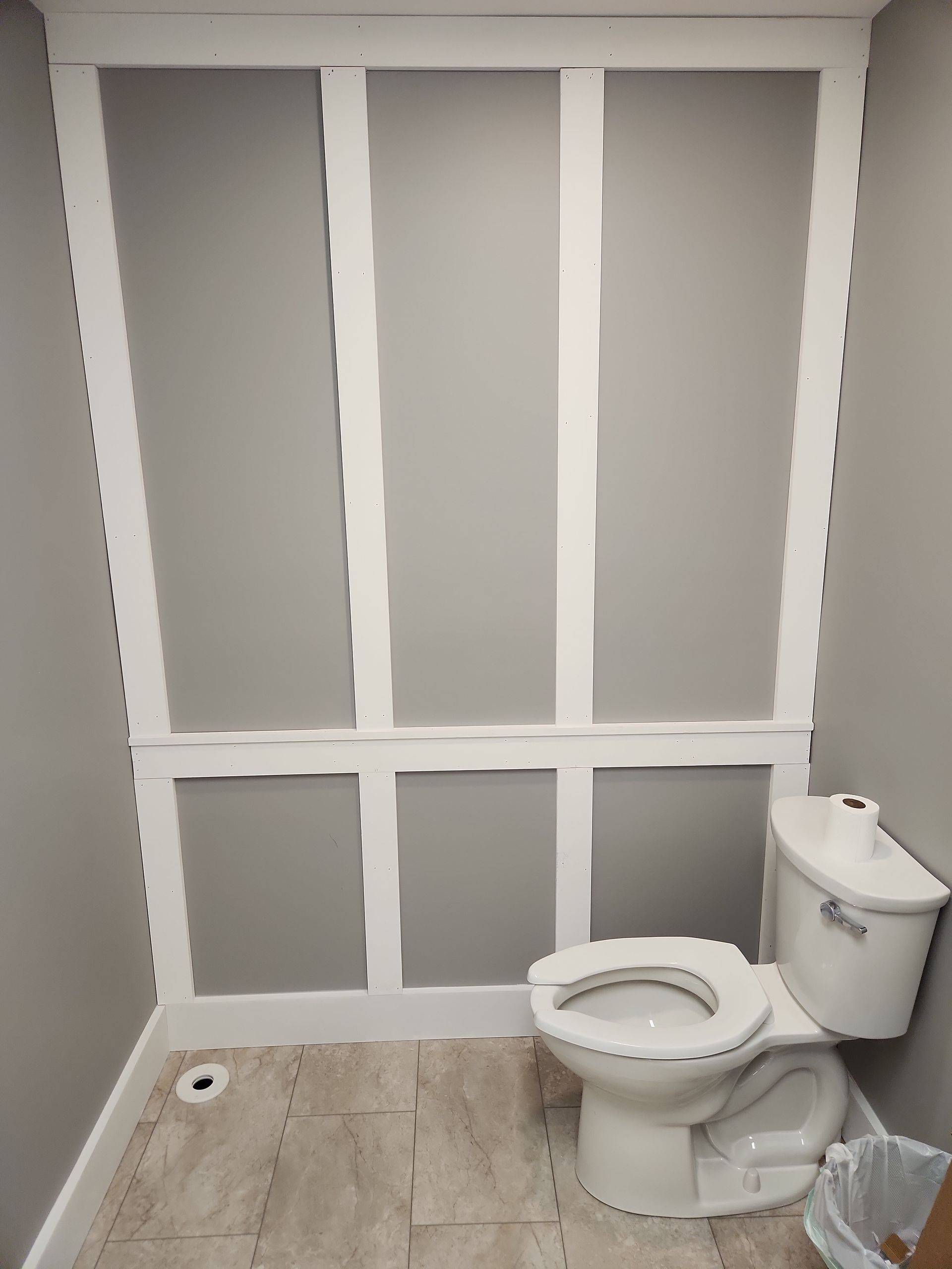 A bathroom with a toilet and a trash can