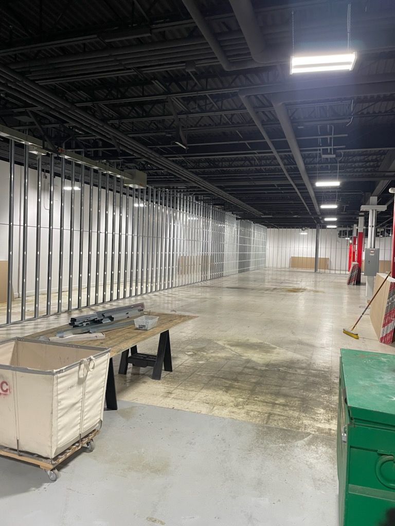 A large empty warehouse with a ceiling that is being built.