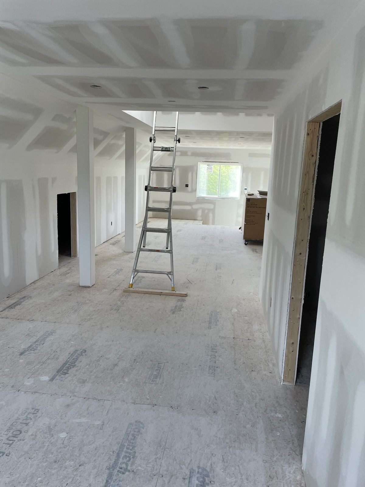 An empty room with a ladder on the floor