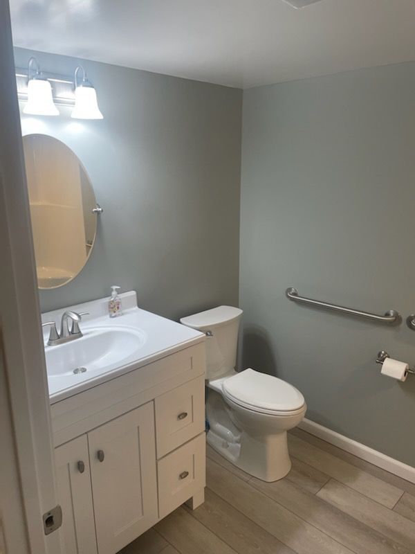A bathroom with a sink , toilet and mirror.