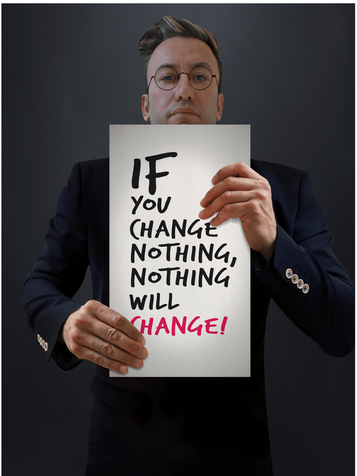 Man in suit holds sign: