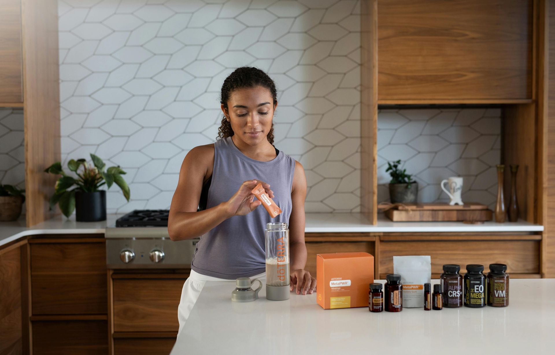 Woman in kitchen pouring powder into a glass, near supplements.