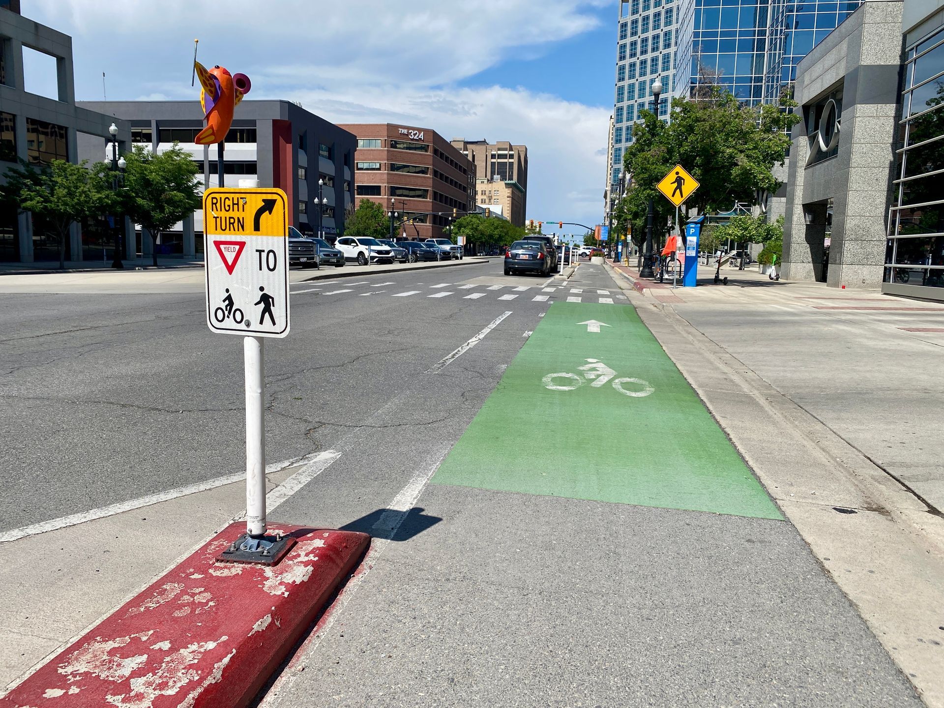 Protected bike lane in an urban roadway with green striped bicycle lane