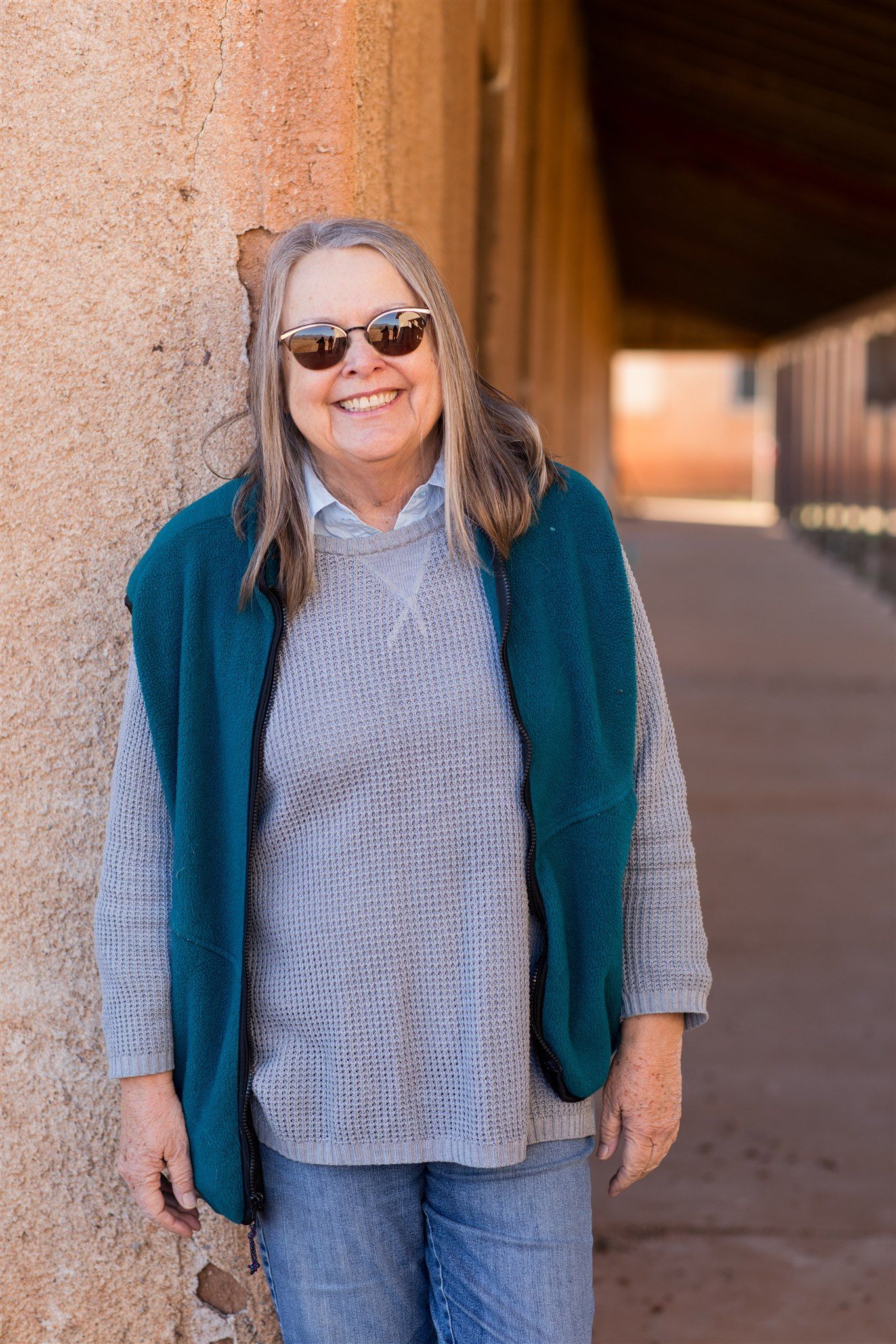 Woman smiles holding champagne, Uluru in background.