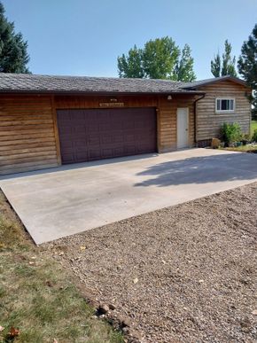 Single-story house with a double garage and concrete driveway on a sunny day