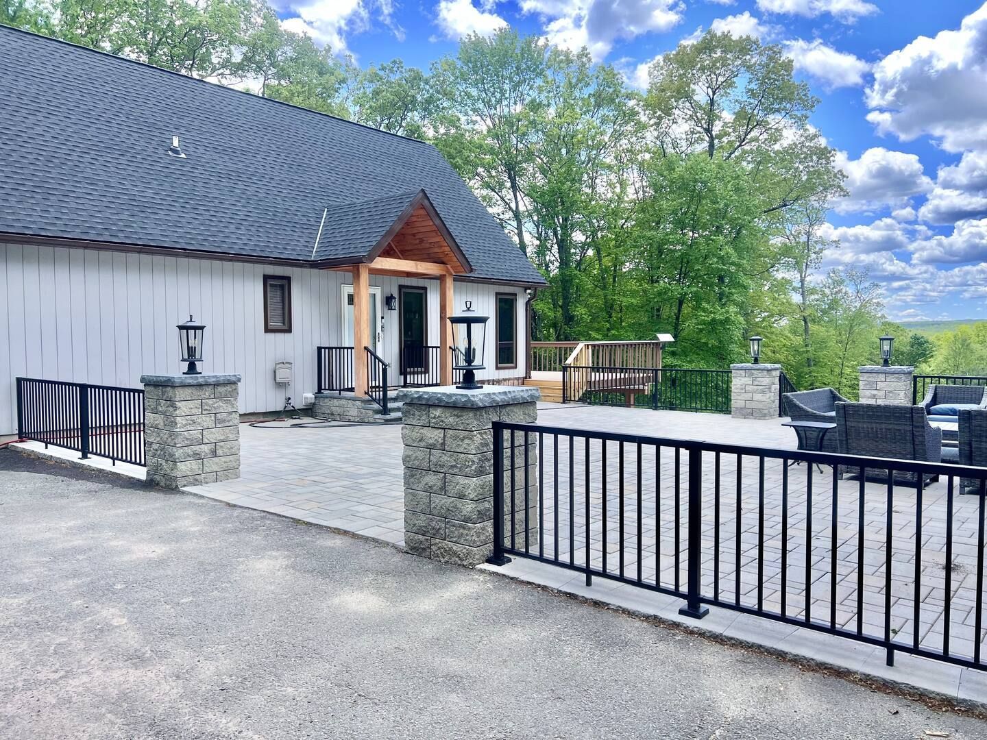 Person riding an ATV follows another on a dirt path under a bright blue sky.