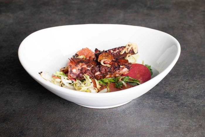 A white bowl filled with food on a table.