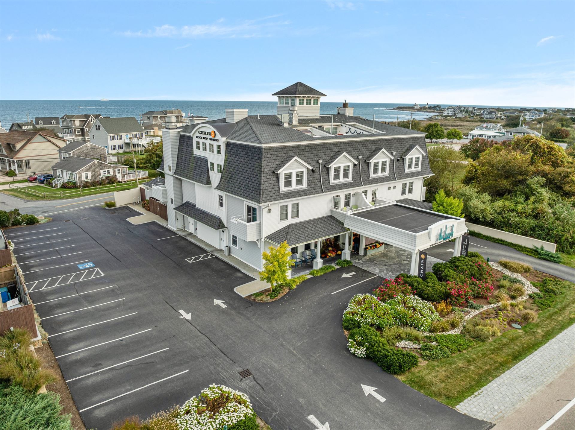 An aerial view of a hotel with a parking lot in front of it.