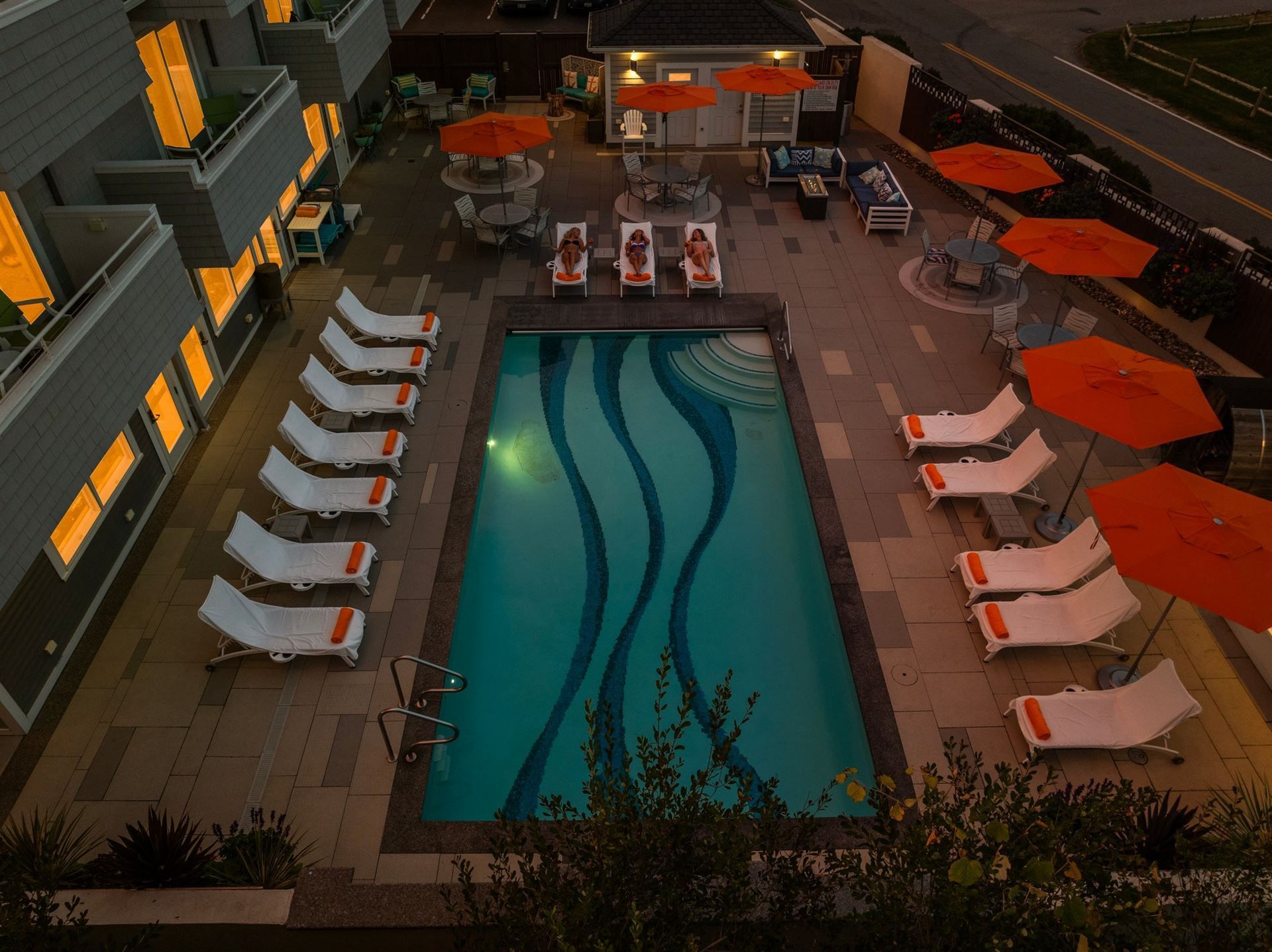 An aerial view of a large swimming pool surrounded by chairs and umbrellas.