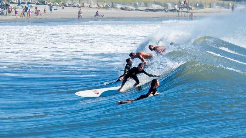A group of people are riding waves on surfboards in the ocean.