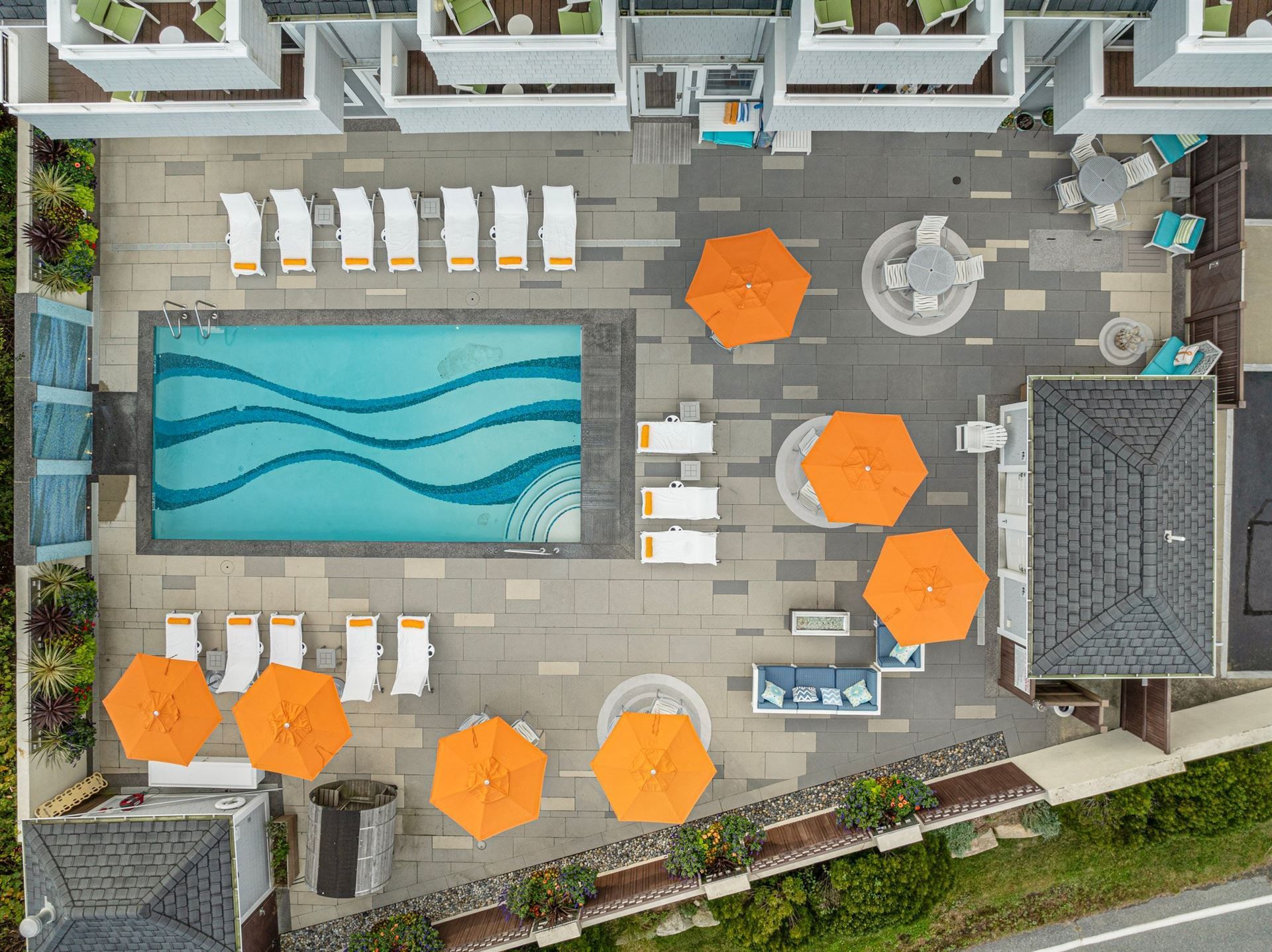 An aerial view of a swimming pool surrounded by chairs and umbrellas.