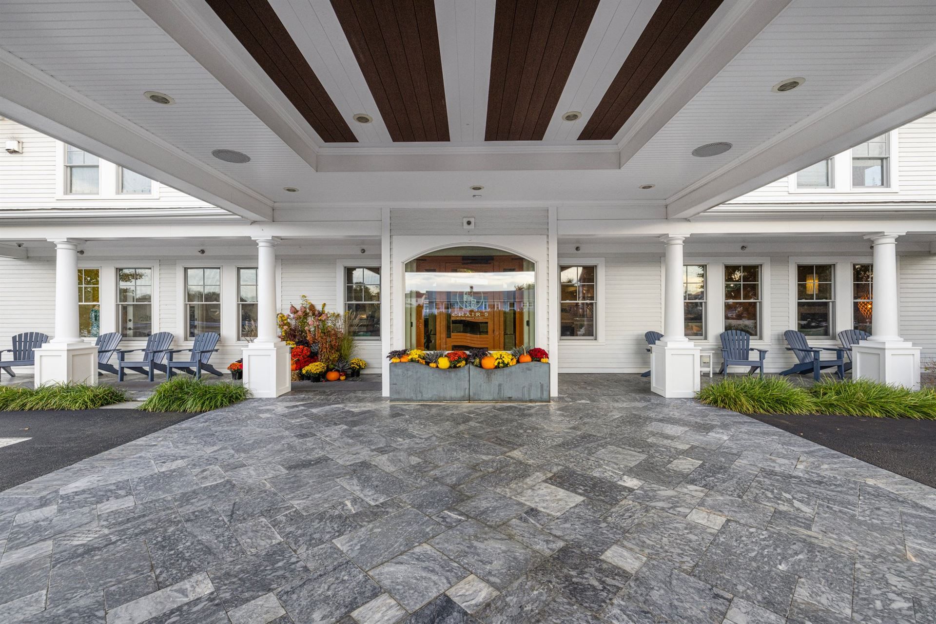 A large white house with a large driveway leading to the entrance.