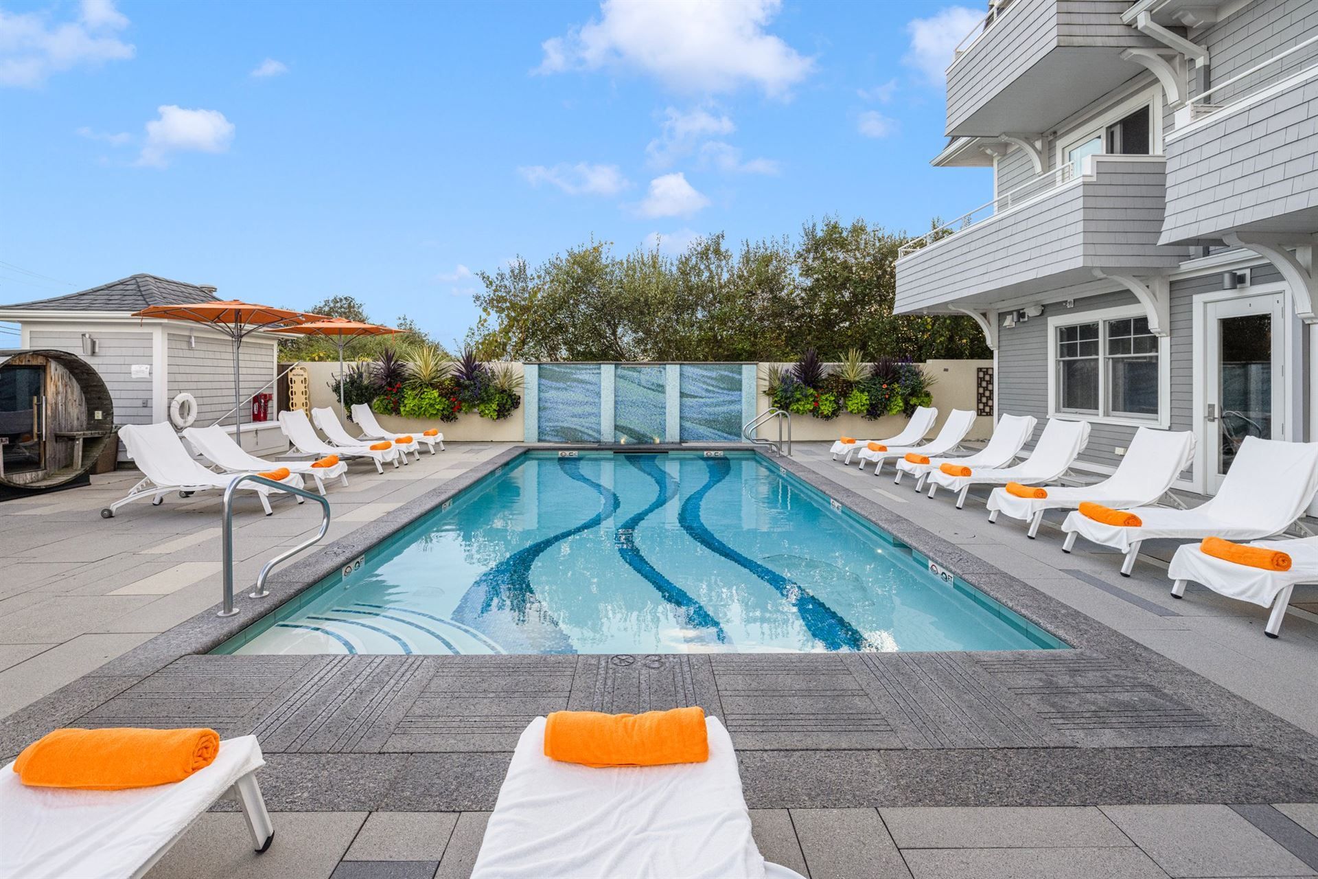A large swimming pool surrounded by lounge chairs and umbrellas.