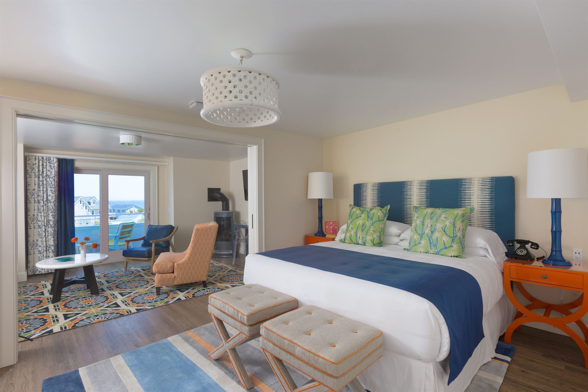 A hotel room with a king size bed and two benches