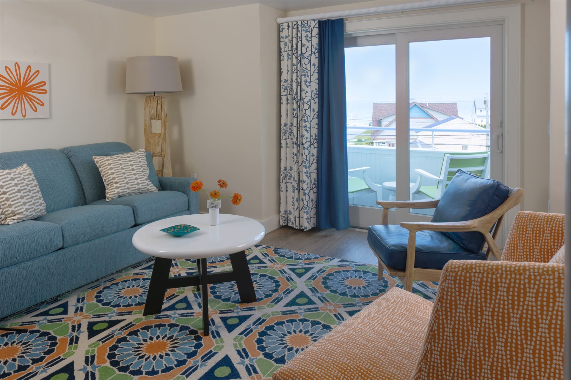 A living room with a blue couch , chairs , and a coffee table.