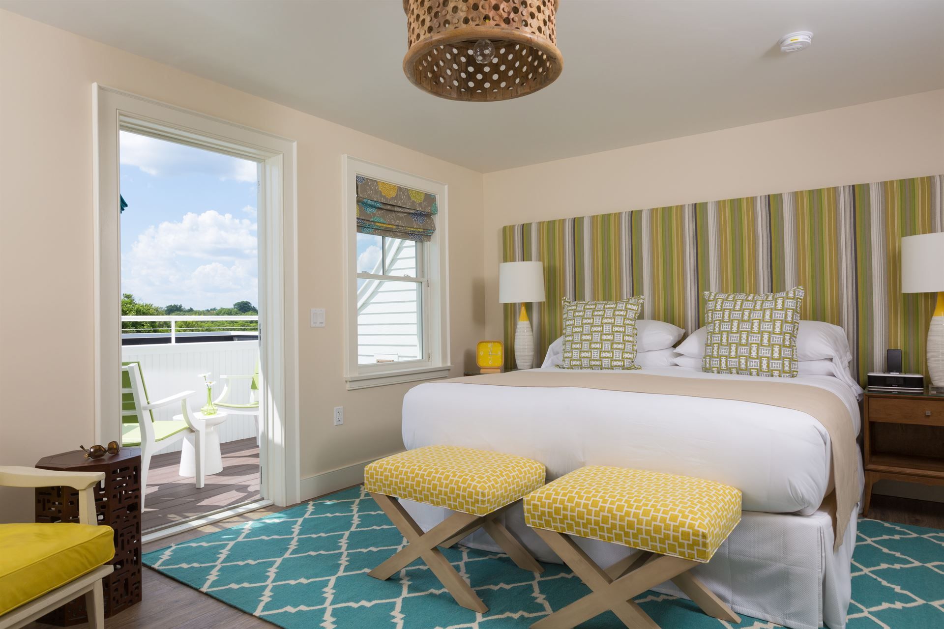A hotel room with a king size bed and a balcony.